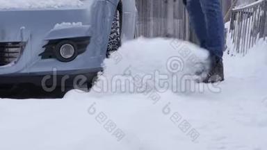 冬<strong>天降</strong>雪后，他在停车场清理汽车周围的积雪。 手持铁锹的人
